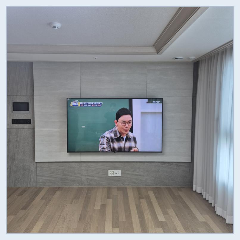 벽에 부착한 TV와 주변 공간의 조화를 살펴보는 사진 · 체결 나사와 잠금